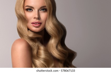 Blonde  Girl With Long  And  Volume Shiny Wavy Hair .  Beautiful  Woman Model With Curly Hairstyle .