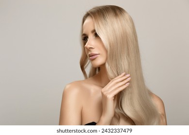 Blonde girl with long wavy hair dyeing ombre touches her hair with her hand. Beautiful fashion woman - Powered by Shutterstock