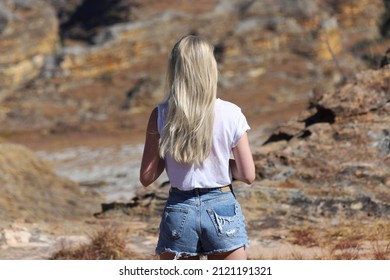 Blonde girl looking away in rocky mountains