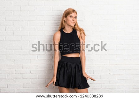 Blonde girl on white brick wall background