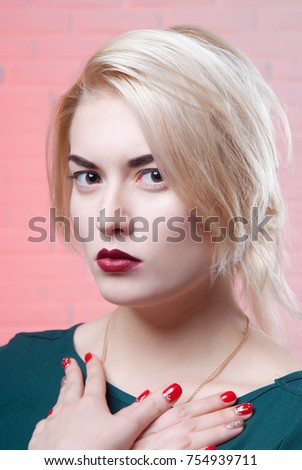 Blonde girl with pin-up makeup folded arms on the light pink background close-up