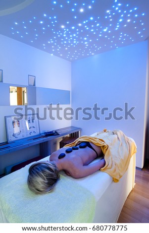 blonde girl and stone on the skin, in blue room