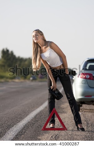 blonde girl with suitcase on the road