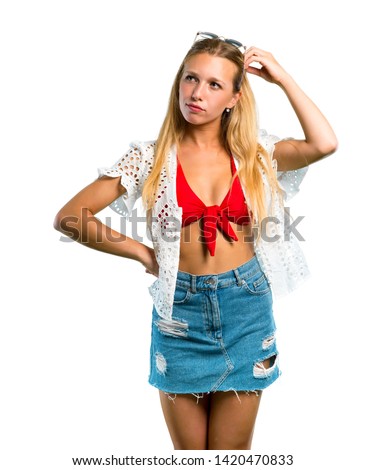 Blonde girl in summer vacation having doubts and with confuse face while scratching head on isolated white background