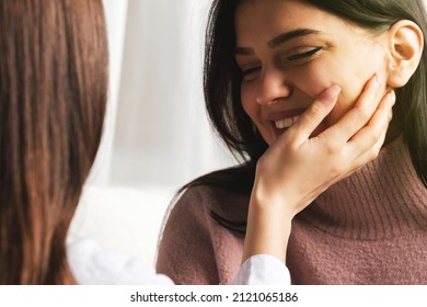 Blonde Girl Touching Her Smiling Brunette Girlfriend Cheek With Hand, Enjoying Intimate Tender Sensual Moment Together .