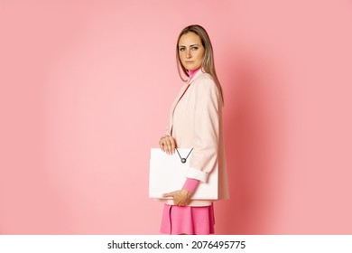 Blonde Hair Business Woman 30-35 Years Old Holding Document On Clipboard Or Falder On Pink Background. Serious Business Woman Looking At Camera. Side View. Studio Shot