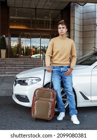  Blonde Hair Handsome Young Man In Beige Jacket And Blue Jeans Got Out Of The Car And Going To The Hotel Entrance With Bag And Hug The Girl