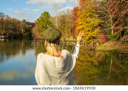 blonde hair woman standing near the lake. Beautiful colorful nature