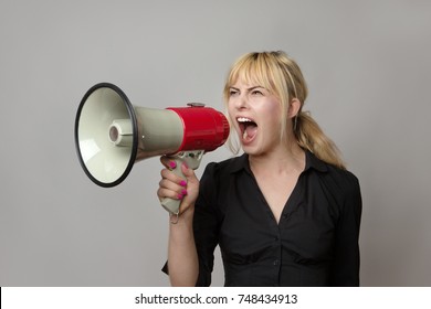 blonde haired business woman shouting into a bullhorn