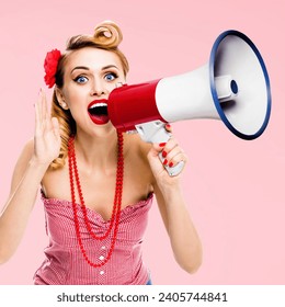 Blonde haired woman holding mega phone megaphone loudspeaker, shout something. Girl in red pin up style clothing, rose pink colour. Female model in retro vintage studio concept. Square photo