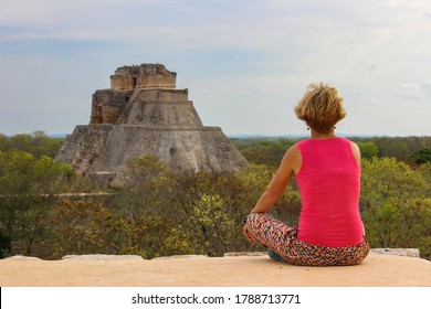 Blonde happy girl on her holiday in Mayan temple Uxmal archeological site,Mexico. UNESCO site. Ancient Maya city and the Pyramid of the Magician in Yucatan.Wanderlust travel serenity background.