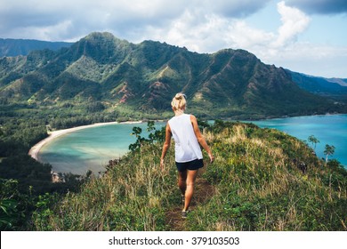 Blonde hiker looks over the ocean on a classic Hawaiian hike. - Powered by Shutterstock