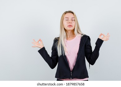  blonde lady in t-shirt, jacket doing meditation with closed eyes and looking relaxed , front view.  - Shutterstock ID 1879857658