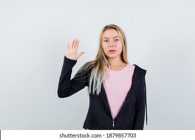  blonde lady waving hand for greeting in t-shirt, jacket and looking sensible , front view.  - Shutterstock ID 1879857703