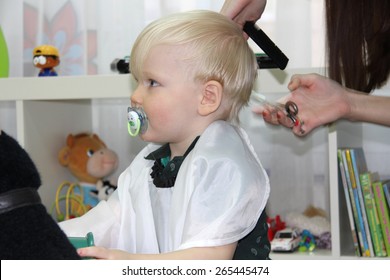 Blonde Little boy cut their hair in a childrens hairdresser, two years baby boy