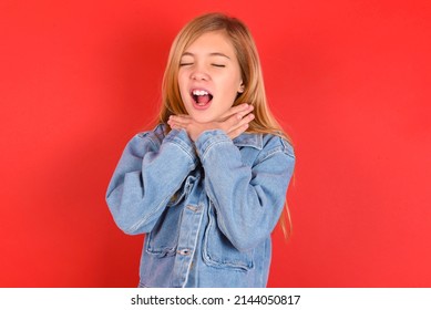 blonde little kid girl wearing denim jacket over red background  shouting suffocate because painful strangle. Health problem. Asphyxiate and suicide concept.