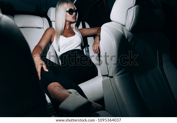 Blonde with long\
legs in a leather white salon.Sexy woman in car.Blonde with\
glasses.Girl with long legs.Sexy young blonde woman in car. Luxury\
car.Sexy blonde in sunglasses\
