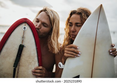 Blonde man and his girlfriend are having fun at sea and posing with surfboards - Powered by Shutterstock