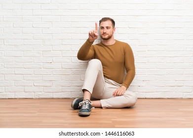 Blonde man sitting on the floor touching on transparent screen