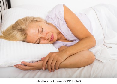 Blonde Mature Woman Sleeping On White Pillow In Bed At Home 