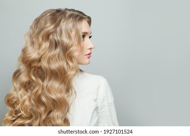 Blonde model woman with long healthy curly hairstyle, profile