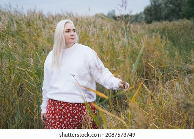 Blonde Plus Size Woman Walking On Reeds Near Seaside.