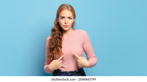 Blonde Pretty Woman Pointing To Self With A Confused And Quizzical Look, Shocked And Surprised To Be Chosen