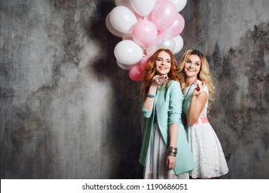 Blonde and redhead. Two happy girlfriends have a fun on the party . Happy and cheerful girl with balloons.