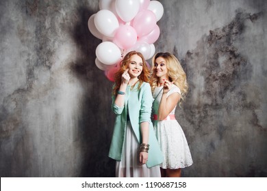 Blonde and redhead. Two happy girlfriends have a fun on the party . Happy and cheerful girl with balloons.