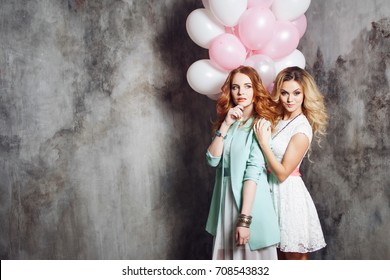 Blonde and redhead. Two young charming girlfriends at the party. Happy and cheerful girl with balloons.