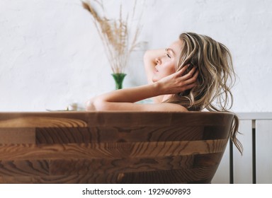 Blonde sensual young woman 35 year plus with long hair takes wooden bath relax at modern bathroom at home