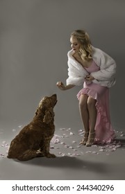 Blonde Socialite Feeding Snack To Spaniel Dog