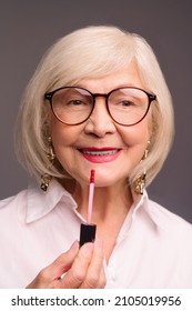 Blonde Stylish Senior Woman Putting Lip Gloss On Her Lips