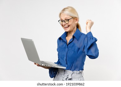 Blonde successful excited employee smiling business woman 40s wear blue shirt glasses ormal clothes hold laptop pc computer do winner gesture clench fist isolated on white background studio portrait
