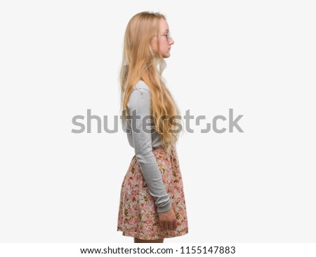 Blonde teenager woman wearing flowers skirt looking to side, relax profile pose with natural face with confident smile.