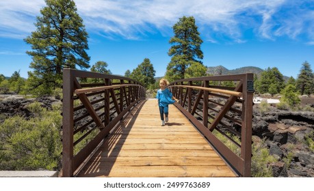 Blonde Toddler crossing wooden bridge in Northern Arizona forest during day - Powered by Shutterstock