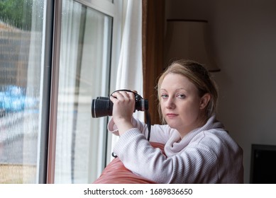  Blonde White Female Nosy Neighbour, Looking Out Of A Window Holding Binoculars. 