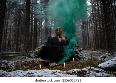 Blonde witch in a black coarse cassock sits on moss in a snowy forest and conjures. - Powered by Shutterstock