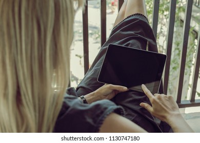 Blonde Woman From Back Reading From Tablet Ipad Device In A Relaxing Holidays Way, Full Screen