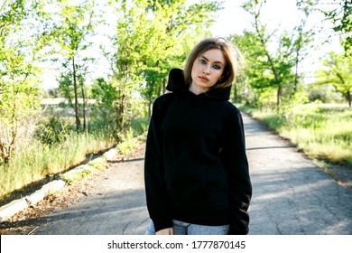 blonde woman in black hoodie posing in the park, mock up clothes for printing
