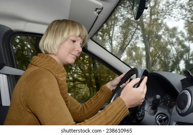 Blonde woman in car using mobile phone