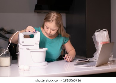 A Blonde Woman Chef Videoblogger Cooking In The Kitchen And Filming, Online Learning Or Remote Cooking Class Concept. Streaming Live Video. Cooking Tutorial