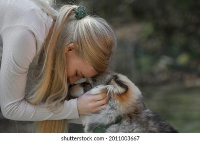 A Blonde Woman Cuddling A Finnish Lapphund Dog, They Have Matching Fashion Accessories