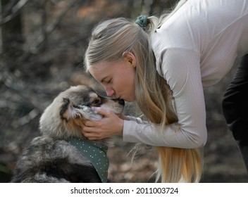 A Blonde Woman Cuddling A Finnish Lapphund Dog, They Have Matching Fashion Accessories