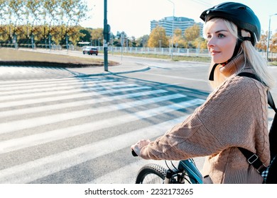Blonde Woman cyclist crossing zebra on the street. Female commuting to work, riding bicycle on city crossroad. Copy space - Powered by Shutterstock
