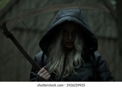A blonde woman is dressed up as a Grim Reaper
