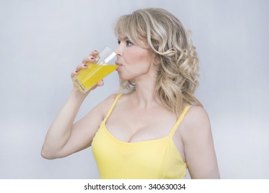 Blonde Woman Drinking An Orange Juice 