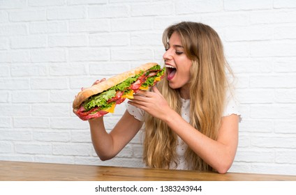 Blonde Woman Eating A Giant Sandwich