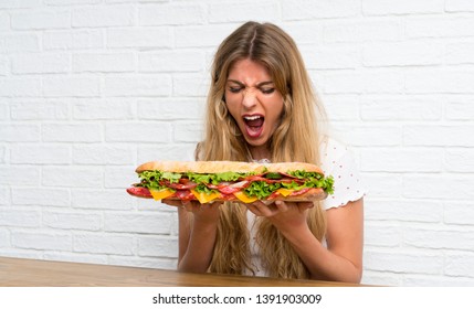 Blonde Woman Eating A Giant Sandwich