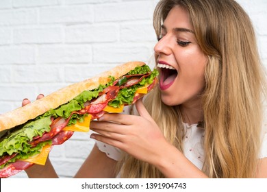 Blonde Woman Eating A Giant Sandwich